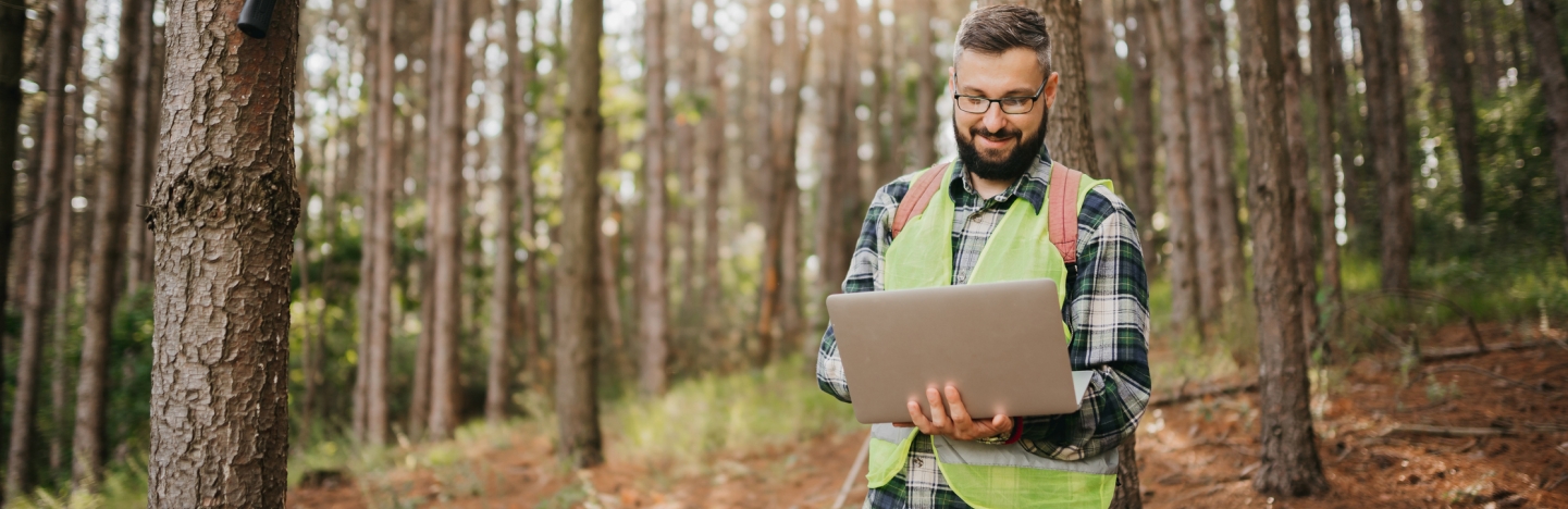 Man with laptop in forest