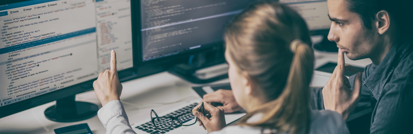 Two people look at a computer together