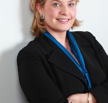 Individual with blonde hair smiling against white backdrop