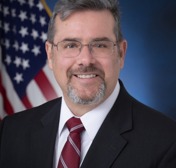 Image of Commissioner Palmer Headshot with flag.jpg