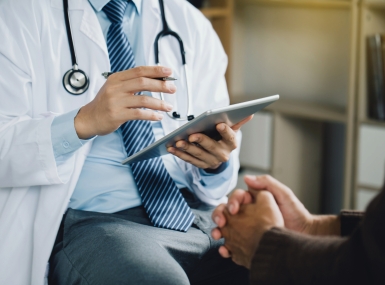 Doctor with tablet and patient