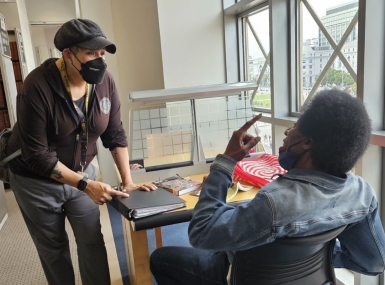 Health and Safety Associate Jen Keys checks in with a regular patron at the San Francisco Public Library.