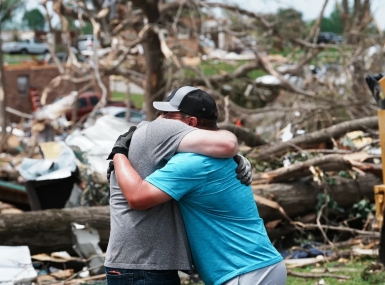 Jeff Davis, left, embraces homeowner Houston Rea, who suffered a total toss of his home, after a tornado tore through his neighborhood in Laurel County, Ky. Photo by Sam Upshaw Jr./Courier Journal