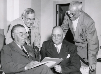 G. Claiborne Blanton, Joseph F. Hammond, Harry Bartell and Stanley Martin review the program for the 1949 National Association of County Officers Annual Conference.