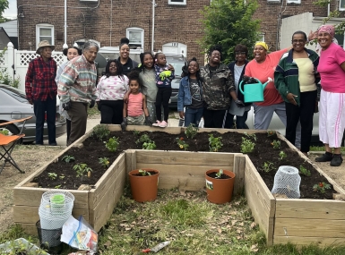 Village members in the Baltimore County neighborhood of Turner Station pause for a photo with Girl Scout Troop 353 by the recently established garden in Chestnut Park. Photo courtesy of Arkia Wade