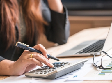 A woman inputs numbers into the calculator