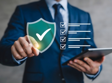 man pointing at a cybersecurity shield with a checkmark and then a checklist is next to it