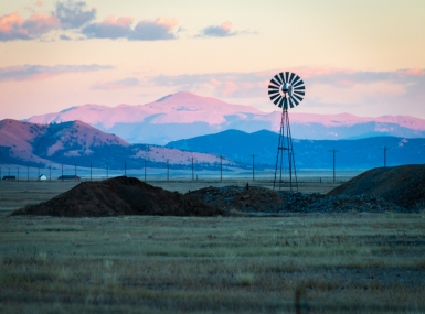 Wind Turbines On Land Against Pikes Peak And Sky During Sunset