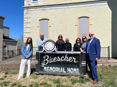 Staff of the Missouri Association of Counties stand in front of the historic “Buescher Memorial Home” sign located at 429 Capitol Ave. in Jefferson City. From left: Intern Isabella Grander, Deputy Director David Owen, Member Engagement Director Carah Bright, Finance and Operations Manager Cindy Wells, Administrative Support Assistant Charlotte Onstott, Event and Marketing Coordinator Meredith Melahn and Executive Director Steve Hobbs. Not pictured due to traveling: Trust Risk Manager Sean McGonigle
