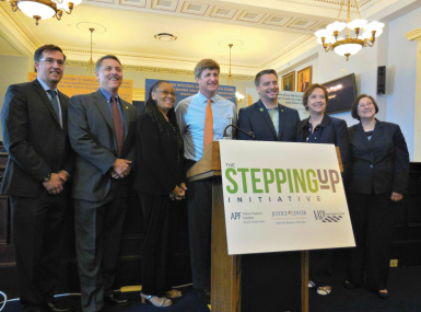 (L-r): Council of State Governments Excecutive Director Michael Thompson; Loudoun County, Va. Sheriff Mike Chapman; Ramsey County, Minn. Commissioner Toni Carter; Rep. Patrick Kennedy (D-Mass.); mental health advocate Paton Blough; NACo Strategic Relations Director Linda Langston and Department of Justice Director of Justice Assistance Denise O'Donnell celebrate the launch of the Stepping Up Initiative in May 2015. Langston, a former Linn County, Iowa supervisor, was a NACo president. Photo by Alix Kashdan