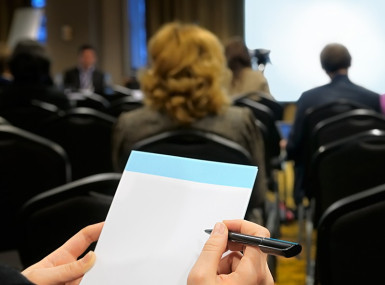 A person takes notes in a meeting