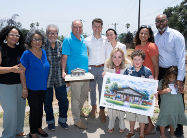 The Wood family, Supervisor Kathryn Barger and nonprofit representatives pose with a model and rendering of the Woods’ home design.  Photo by David Franco for Los Angeles County