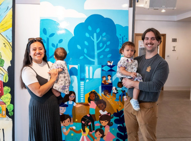 Vivian Piña, one of Brookfield Shops’ featured artists, poses with her family in front of the panel she created of Kiwanis Park. The funding was made possible through the county’s Creative Placemaking grant.