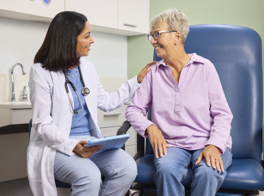 Doctor helping older lady who is a patient in the exam room