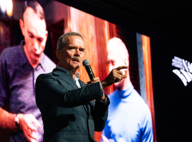 With a photo of the Apollo 11 crew behind him, Col. Chris Hadfield communicates how the world changed with the moon landing in 1969. Photo by Denny Henry