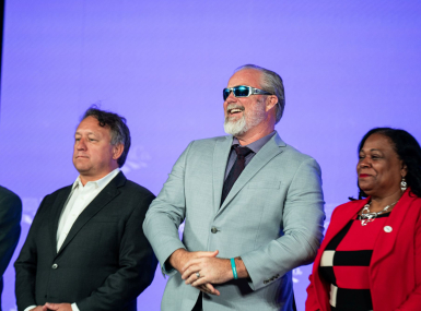 Flanked by West Region Representative Bill Novotny and First Vice President Alisha Bell, former NACo President James Gore takes in the spotlight at the 2026 Annual Conference. Photo by Denny Henry