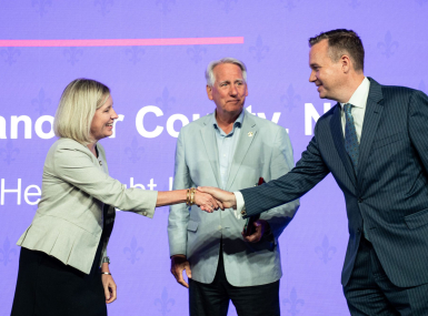 NACo President J.D. Clark congratulates New Hanover County, N.C. Chief Strategy Officer Jennifer Rigby and Commissioner Rob Zapple on the county's Best in Category Civic Eduacation Achievement Award for the Help Right Here program. Photo by Denny Henry