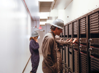 Workers inspect equipment inside a Crusoe data center. Photo courtesy of Crusoe