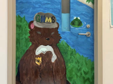 Orange County, N.C.’s Youth Deflection Program connected a youth referred for graffiti with a local arts nonprofit, where the young person received mentorship and found a positive outlet for their artistic talents, including helping paint this mural on a school resource officer’s door.