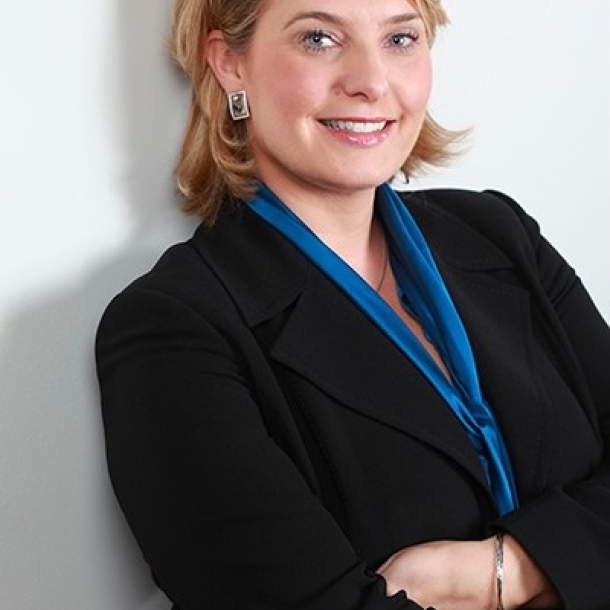 Individual with blonde hair smiling against white backdrop