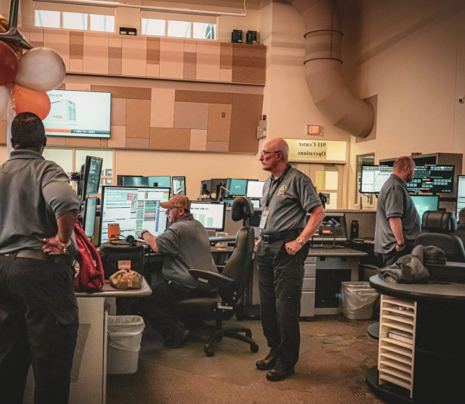 John Farrell (center) ignores the balloons and gets to work on his 50th anniversary with the New Castle County 911 Communications department. Photo courtesy of New Castle County