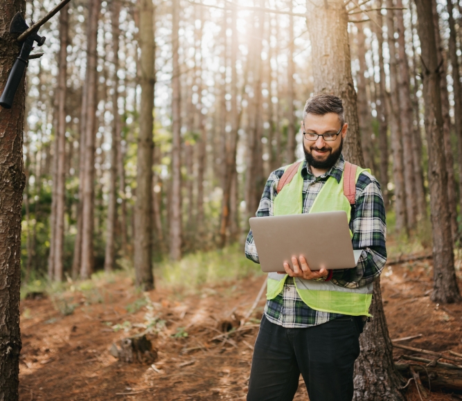 Man with laptop in forest