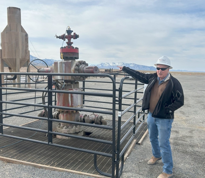 John McLennan shows off a geothermal wellhead on the Utah FORGE site in Beaver County, Utah. Photo by Charlie Ban