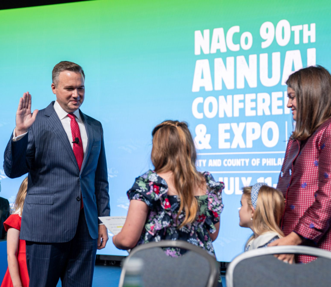 J.D. Clark takes the oath of office, administered by his daughter, Claire, at the 2025 Annual Conference. Photo by Denny Henry