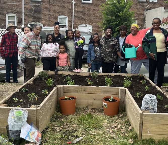 Village members in the Baltimore County neighborhood of Turner Station pause for a photo with Girl Scout Troop 353 by the recently established garden in Chestnut Park. Photo courtesy of Arkia Wade