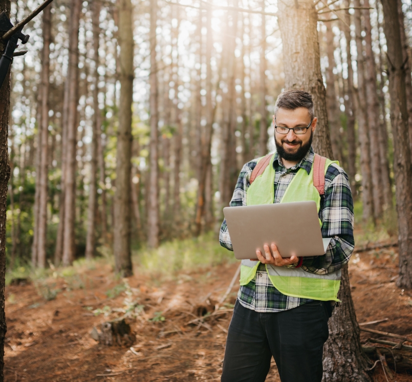 Man with laptop in forest