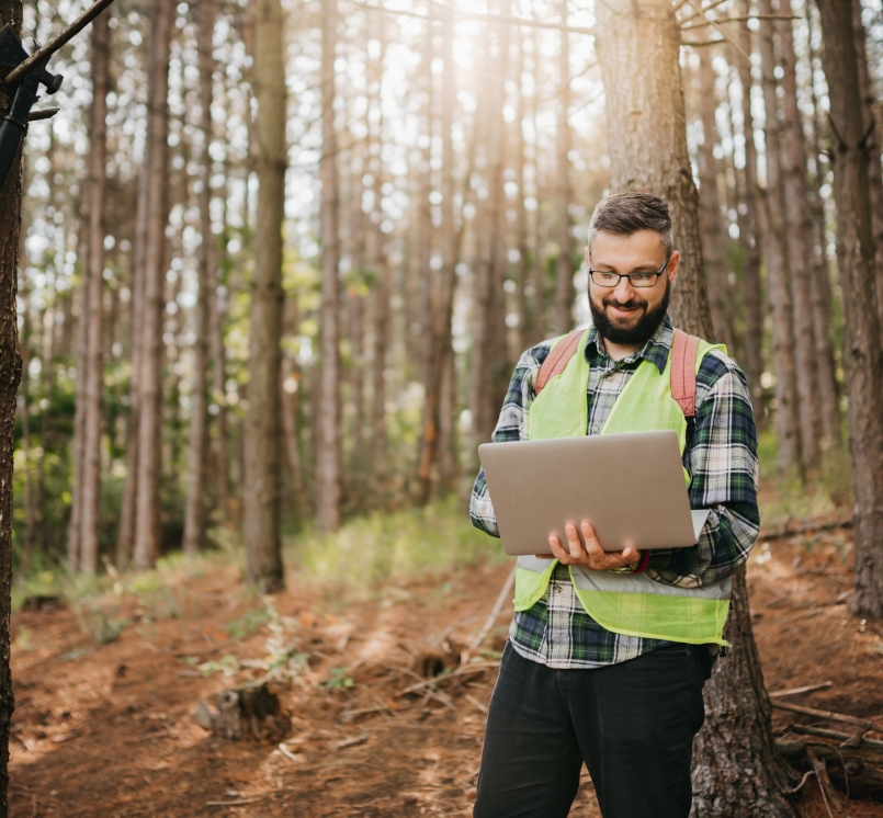 Man with laptop in forest