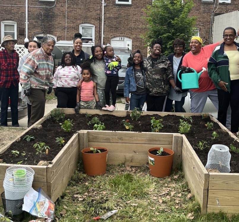 Village members in the Baltimore County neighborhood of Turner Station pause for a photo with Girl Scout Troop 353 by the recently established garden in Chestnut Park. Photo courtesy of Arkia Wade