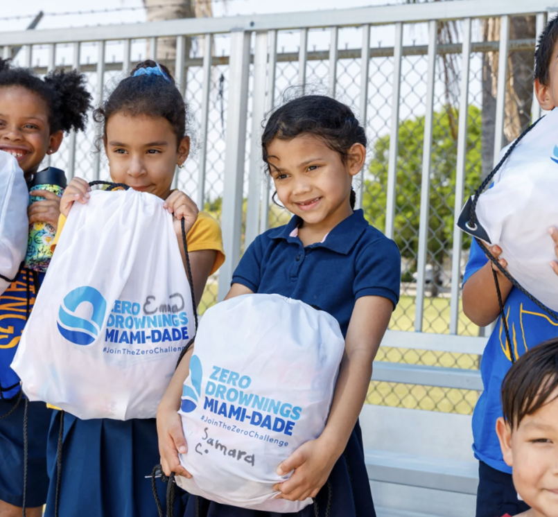 Children participating in Miami-Dade County, Fla.’s Zero Drowning initiative show off their drawstring backpacks.