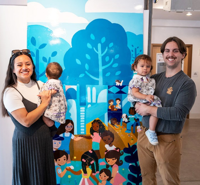 Vivian Piña, one of Brookfield Shops’ featured artists, poses with her family in front of the panel she created of Kiwanis Park. The funding was made possible through the county’s Creative Placemaking grant.