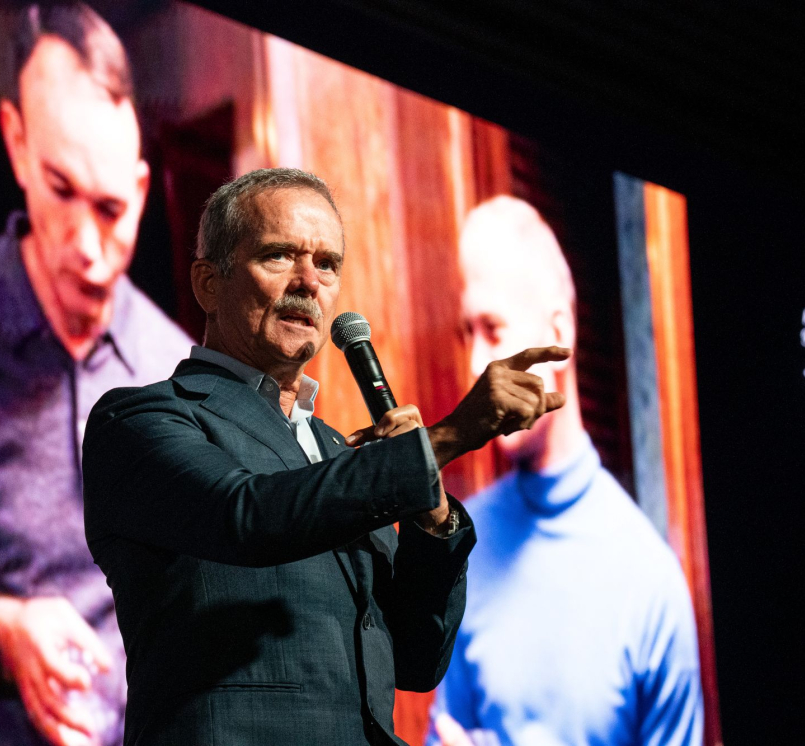 With a photo of the Apollo 11 crew behind him, Col. Chris Hadfield communicates how the world changed with the moon landing in 1969. Photo by Denny Henry