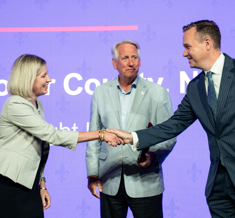 NACo President J.D. Clark congratulates New Hanover County, N.C. Chief Strategy Officer Jennifer Rigby and Commissioner Rob Zapple on the county's Best in Category Civic Eduacation Achievement Award for the Help Right Here program. Photo by Denny Henry