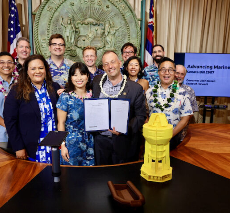Economic Recovery Corps Fellow George Yarbrough (back row, center) poses during a bill signing with Hawaii Gov. Josh Green (holding the bill).