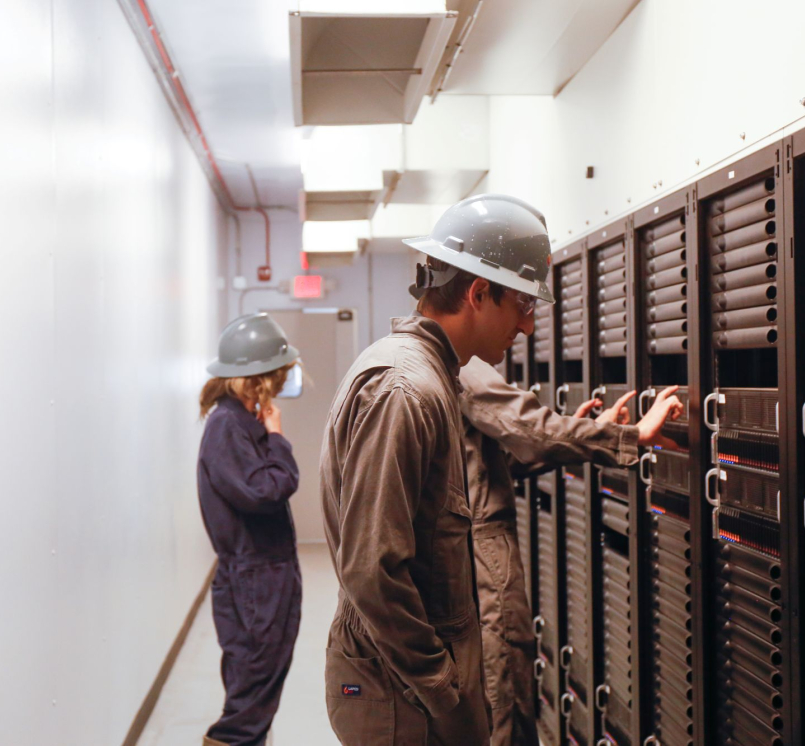 Workers inspect equipment inside a Crusoe data center. Photo courtesy of Crusoe
