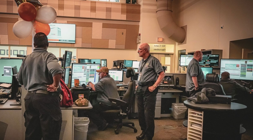 John Farrell (center) ignores the balloons and gets to work on his 50th anniversary with the New Castle County 911 Communications department. Photo courtesy of New Castle County
