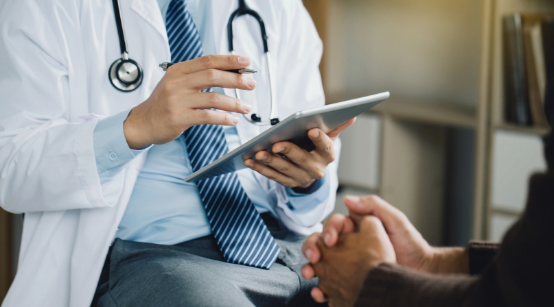 Doctor with tablet and patient