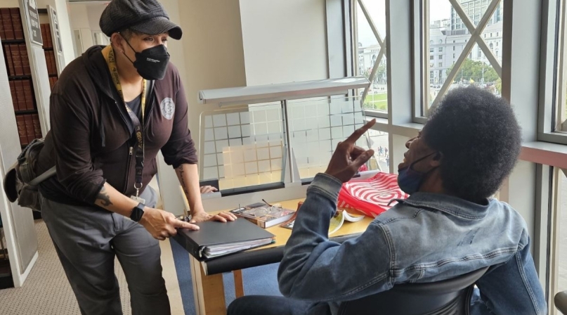Health and Safety Associate Jen Keys checks in with a regular patron at the San Francisco Public Library.