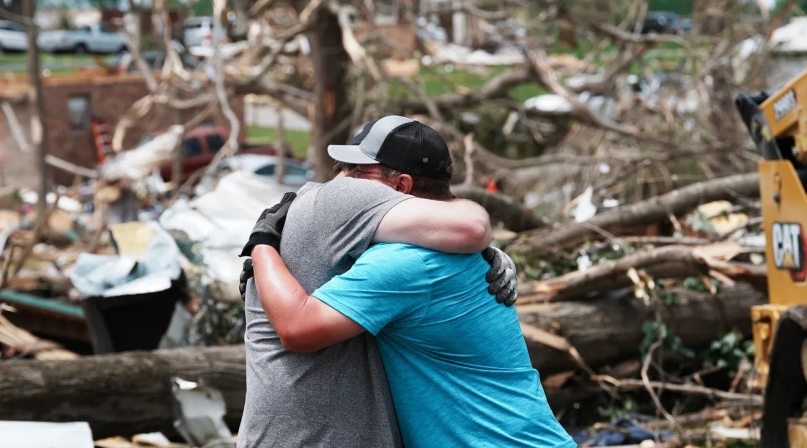Jeff Davis, left, embraces homeowner Houston Rea, who suffered a total toss of his home, after a tornado tore through his neighborhood in Laurel County, Ky. Photo by Sam Upshaw Jr./Courier Journal