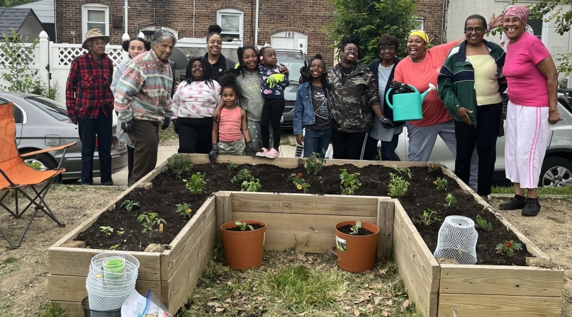 Village members in the Baltimore County neighborhood of Turner Station pause for a photo with Girl Scout Troop 353 by the recently established garden in Chestnut Park. Photo courtesy of Arkia Wade