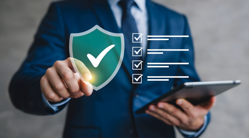 man pointing at a cybersecurity shield with a checkmark and then a checklist is next to it