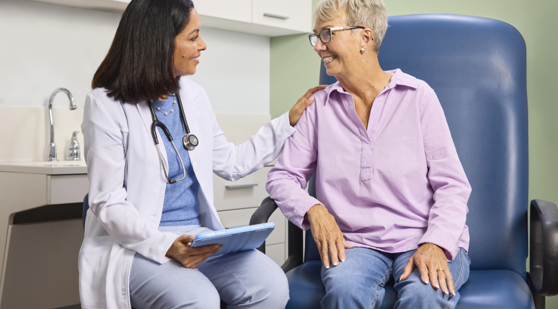 Doctor helping older lady who is a patient in the exam room