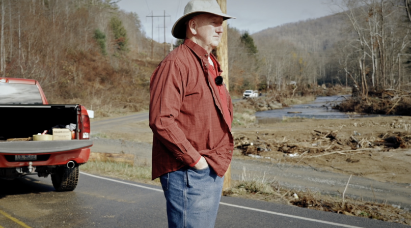 Avery County, N.C. Commissioner Dennis Aldridge surveys damage from Hurricane Helene in 2024 in this still from the North Carolina Association of County Commissioners’ documentary, “Rising Above Helene,” directed by Chris Baucom of 100 Strong Productions. 