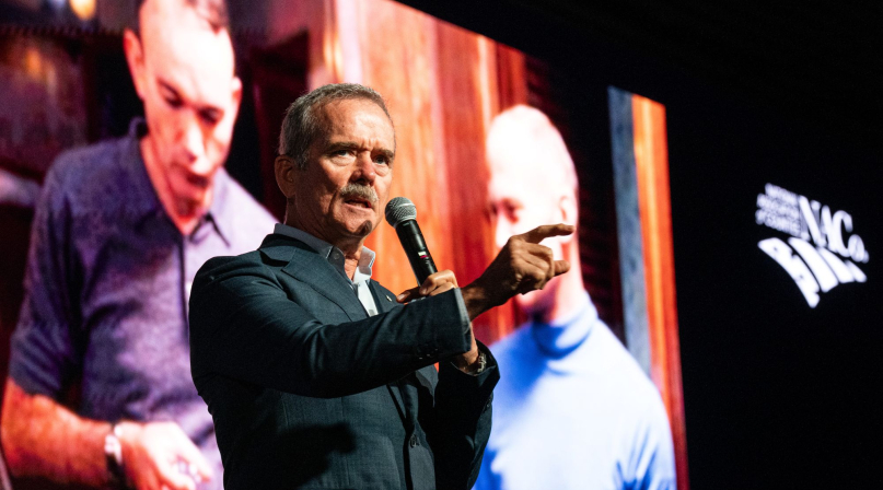 With a photo of the Apollo 11 crew behind him, Col. Chris Hadfield communicates how the world changed with the moon landing in 1969. Photo by Denny Henry