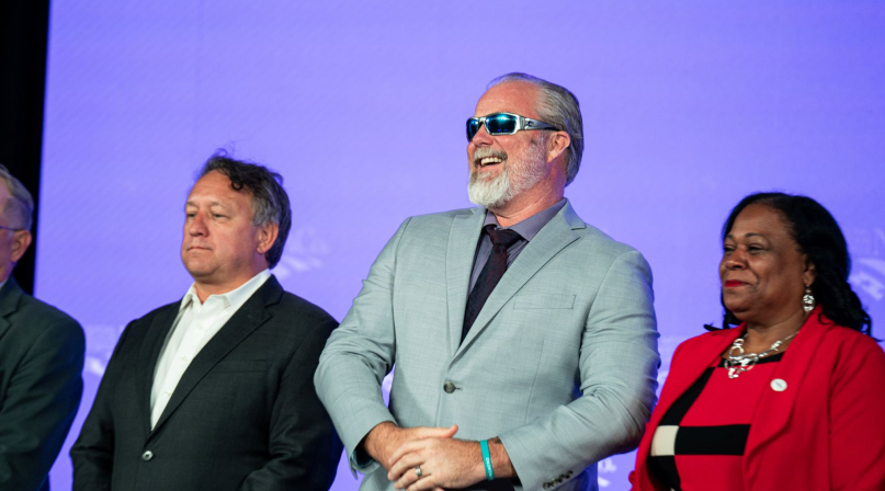 Flanked by West Region Representative Bill Novotny and First Vice President Alisha Bell, former NACo President James Gore takes in the spotlight at the 2026 Annual Conference. Photo by Denny Henry