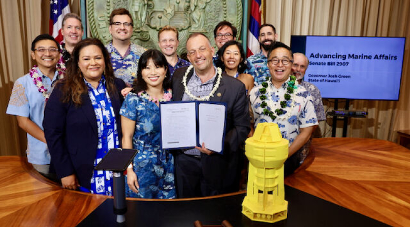 Economic Recovery Corps Fellow George Yarbrough (back row, center) poses during a bill signing with Hawaii Gov. Josh Green (holding the bill).