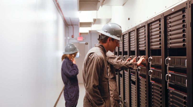Workers inspect equipment inside a Crusoe data center. Photo courtesy of Crusoe